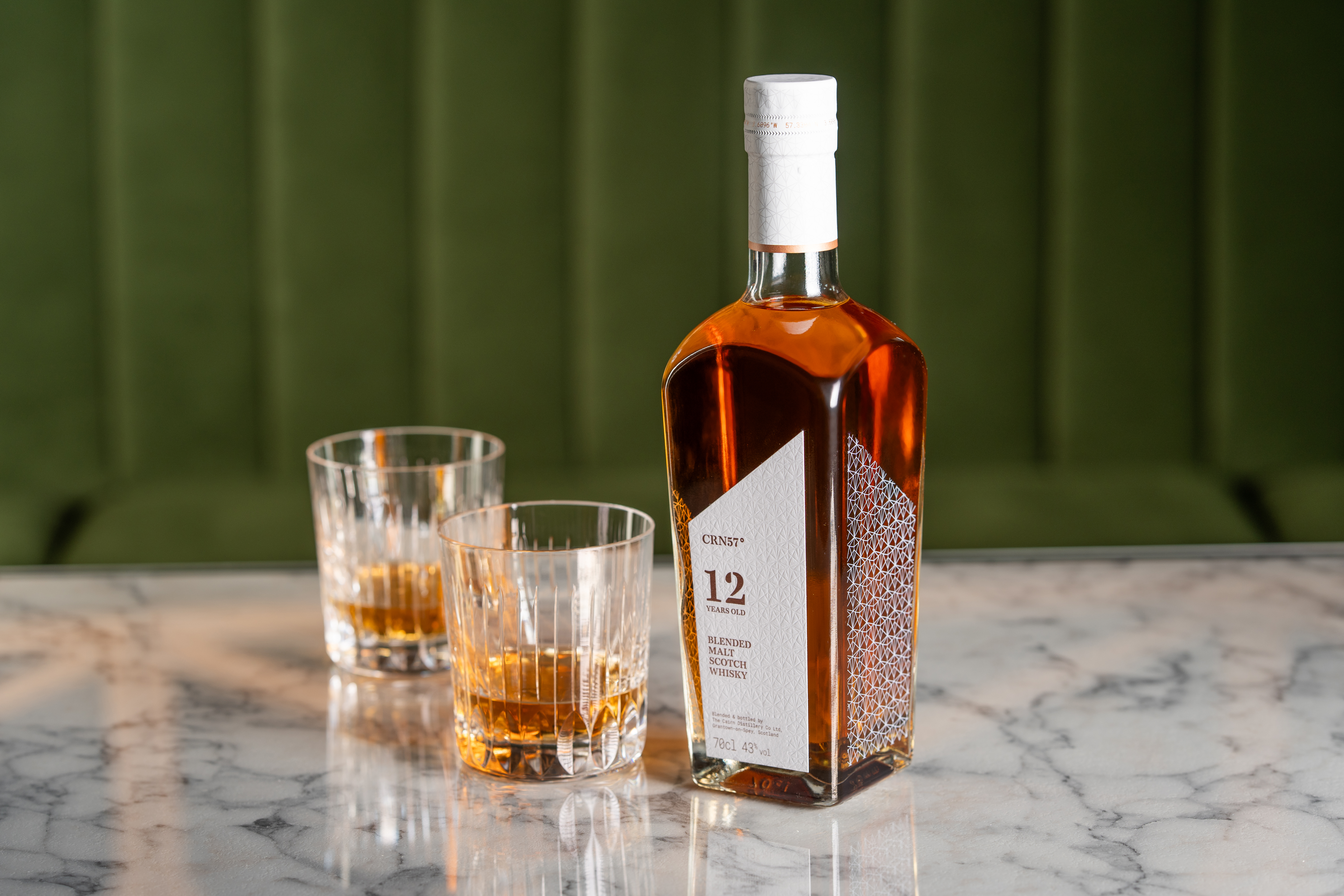 A whisky bottle containing CRN57 12 year old blended malt Scotch whisky and two glasses