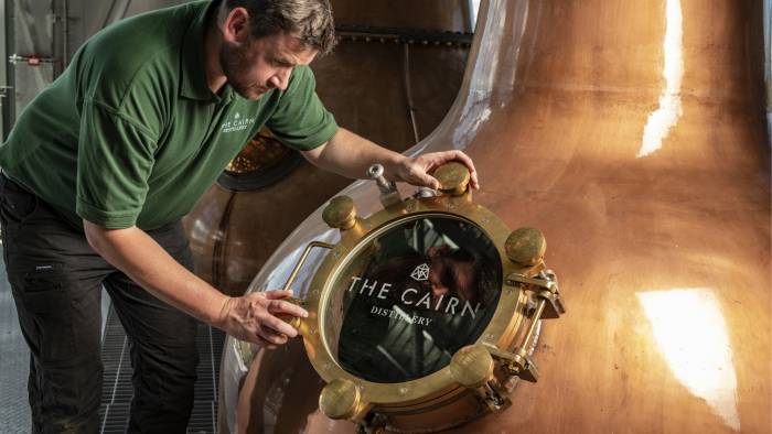 Person inspecting whisky still